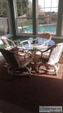 Glass top table w4padded wicker shivel chairs on casters